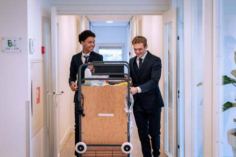 Twee studenten met een schoonmaakdag in gang